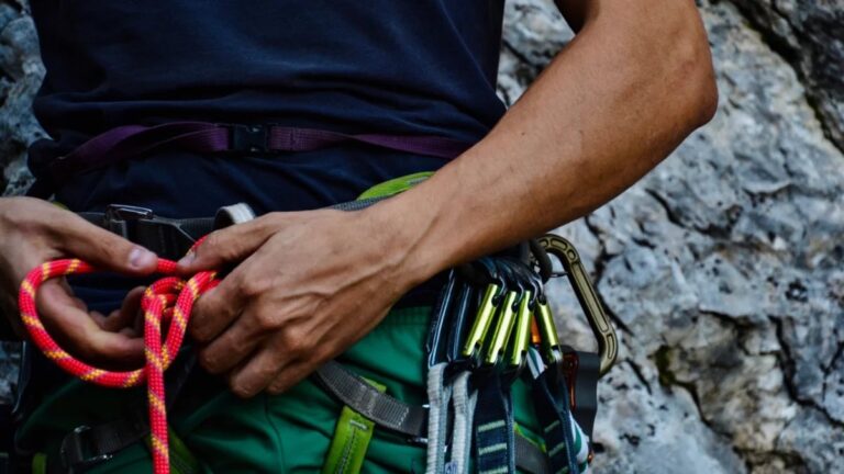 Climbing instructor checking harness and rope