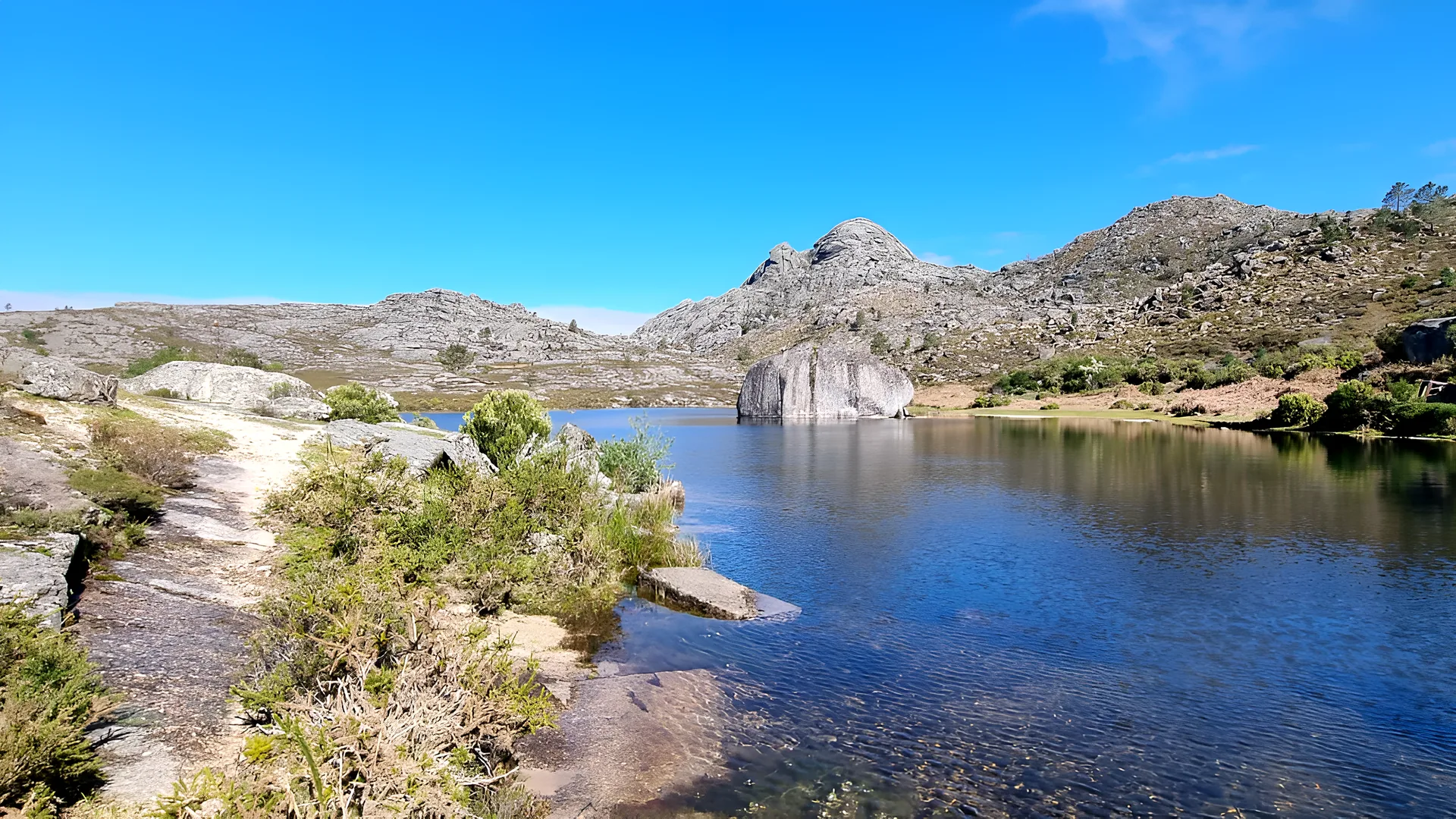 Mountain lagoon, Peneda-Gerês Mountain lagoon with a large granite boulder on a sunny day in Peneda-Gerês National Park, Northern Portugal