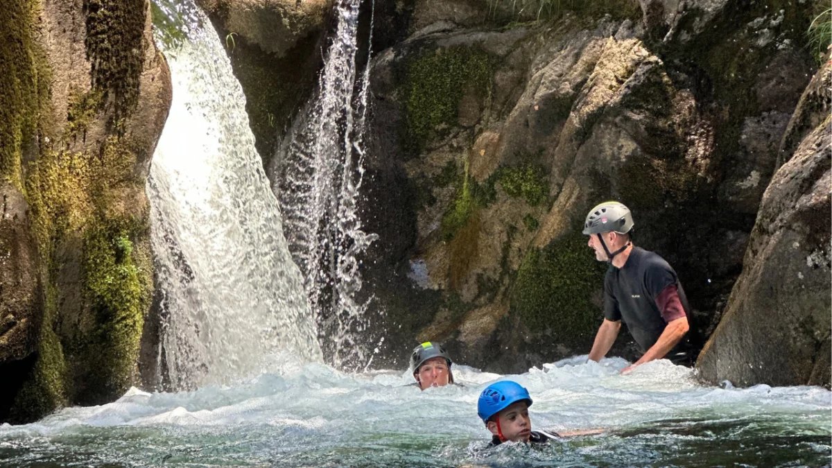 River trekking under a waterfall in Peneda-Gerês National Park