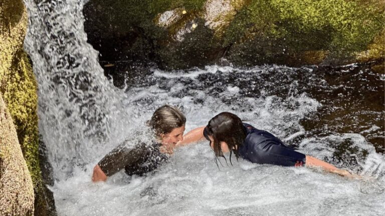 Sliding down a small waterfall while river trekking in Gerês