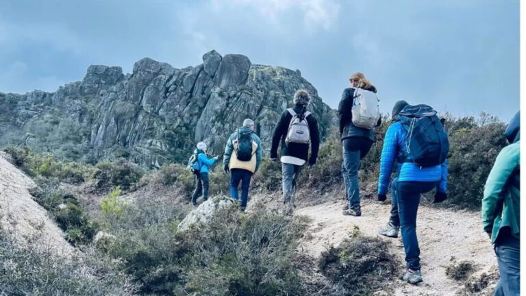 Walking group among granite rocks in the mountains